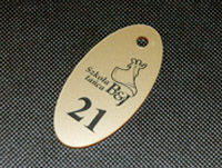 Ozdobny numerek do szatni ze złotej pleksi z barwionym grawerem